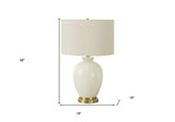 26" Gold and Ivory Ceramic Urn Table Lamp With Cream Drum Shade